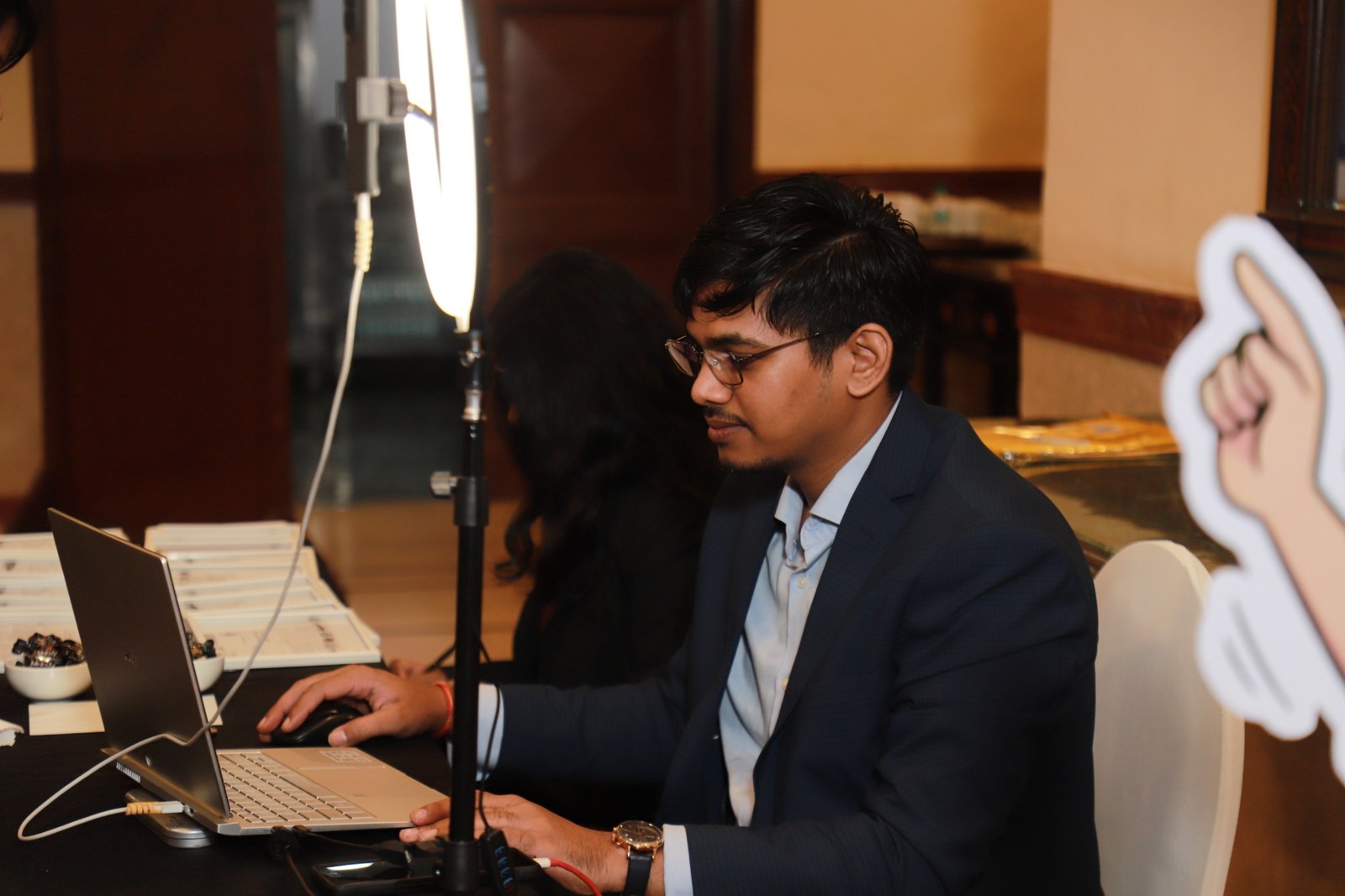 Onsite AI portrait operation with a laptop and ring light at a TOEFL event